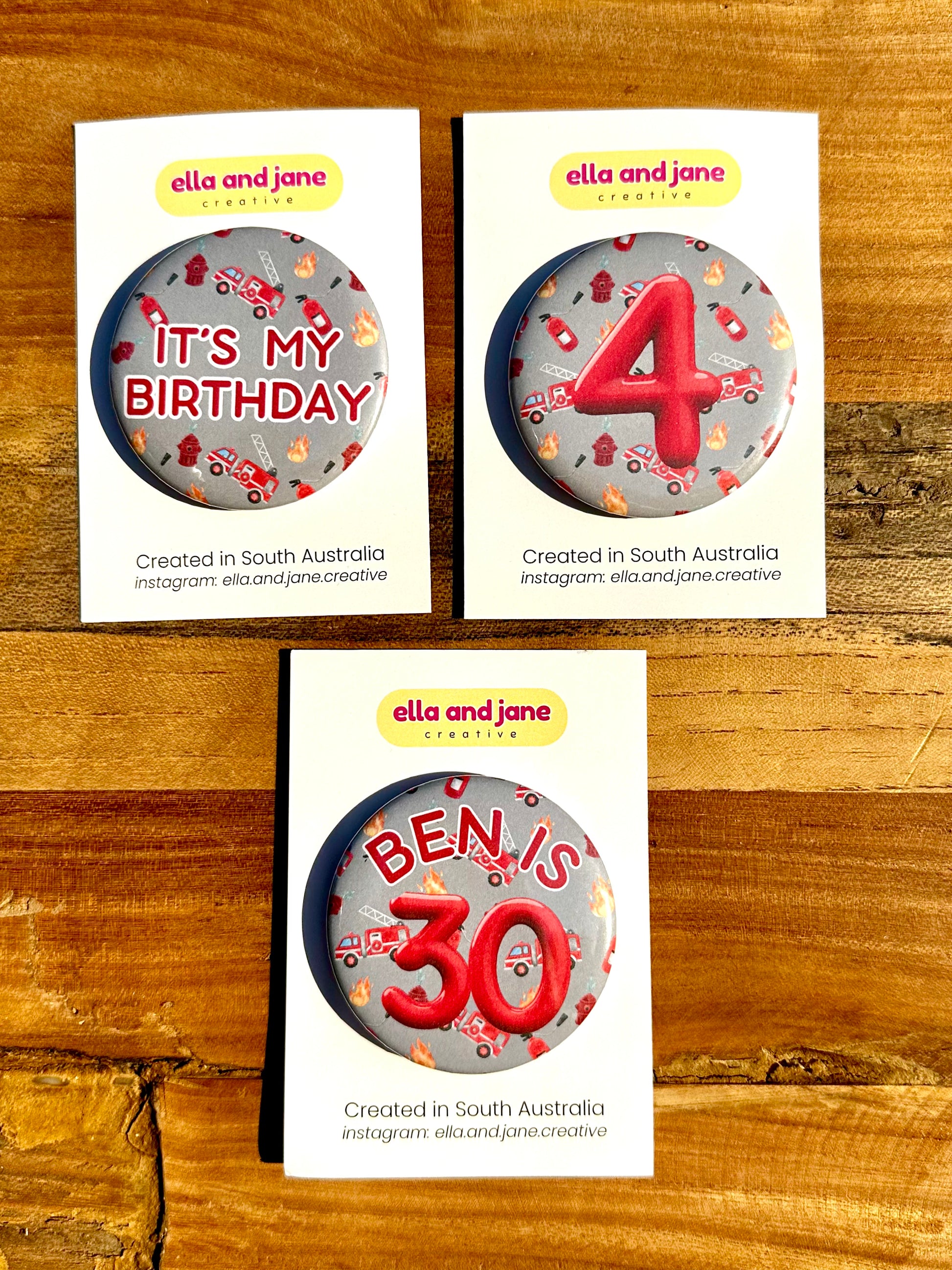 Three firetruck birthday badges. One has the text 'It's my birthday' The other has the number '4' and the third custom badge is 'Ben is 30'.
The backgrounds of the badges are a light rey colour with pictures of flames, fire extinguishers and firetrucks.